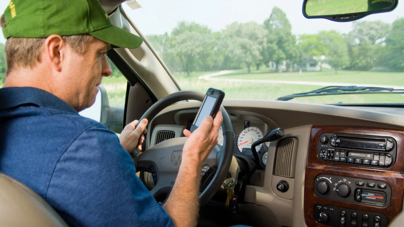 image of man in truck looking at mobile device