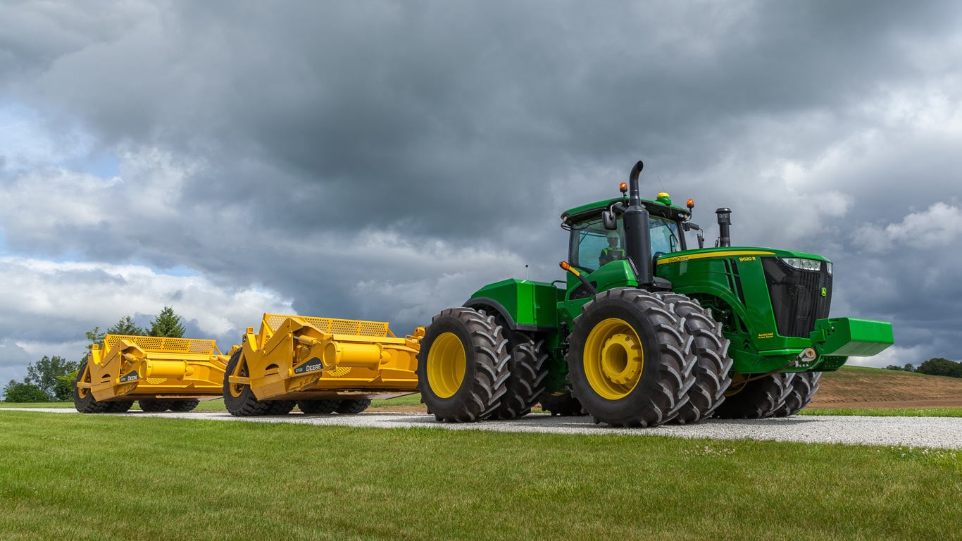 image of dual scrapers attached to tractor on road